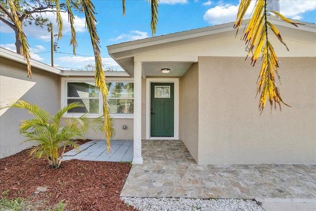 view of exterior entry with a patio