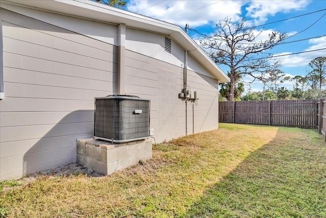 view of home's exterior with central AC unit and a lawn