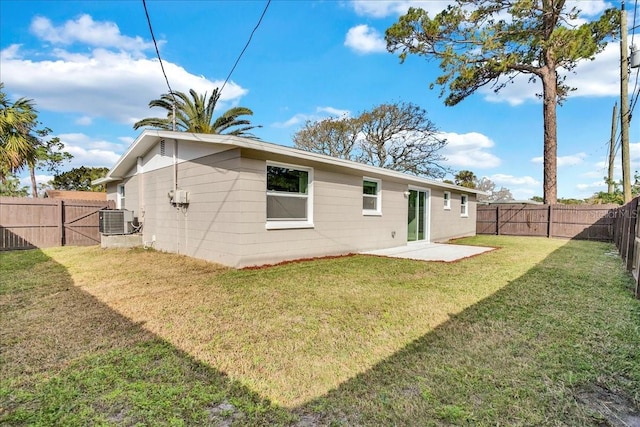 back of property featuring central AC unit and a yard