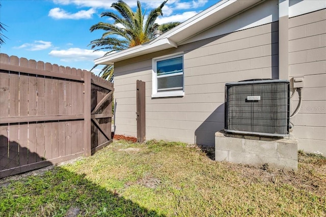 view of side of home with cooling unit and a lawn