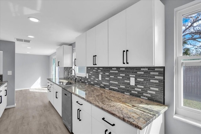 kitchen with sink, white cabinets, and stone countertops