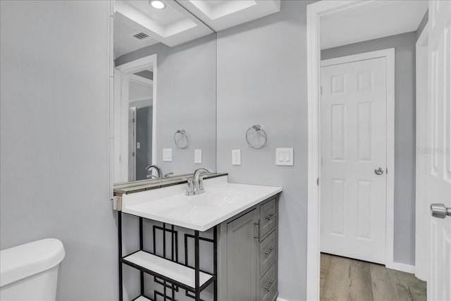 bathroom featuring vanity, hardwood / wood-style floors, and toilet