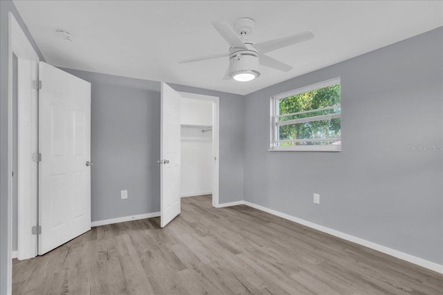 unfurnished bedroom with ceiling fan, light wood-type flooring, and a closet