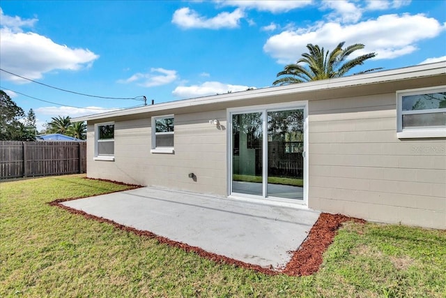 rear view of house featuring a yard and a patio