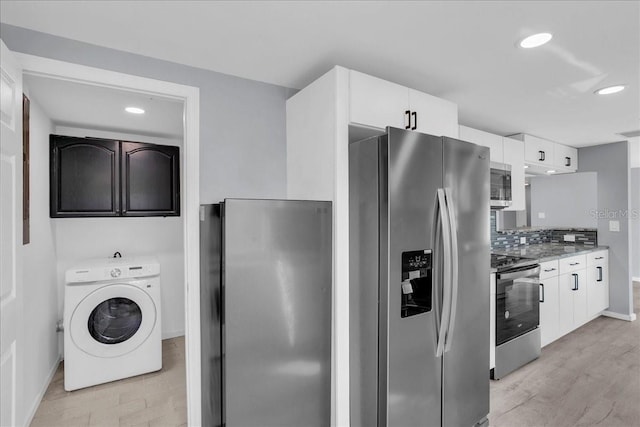 kitchen with tasteful backsplash, light hardwood / wood-style flooring, stainless steel appliances, washer / clothes dryer, and white cabinets