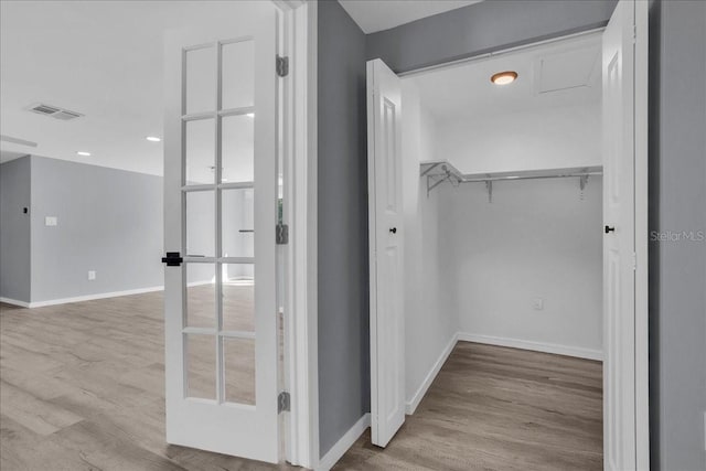 spacious closet with french doors and light wood-type flooring