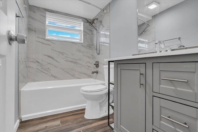 full bathroom with tiled shower / bath combo, wood-type flooring, vanity, and toilet