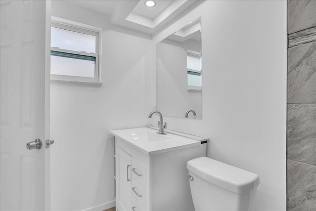 bathroom featuring vanity, a healthy amount of sunlight, and toilet