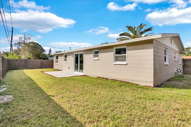 back of property with a patio area and a lawn