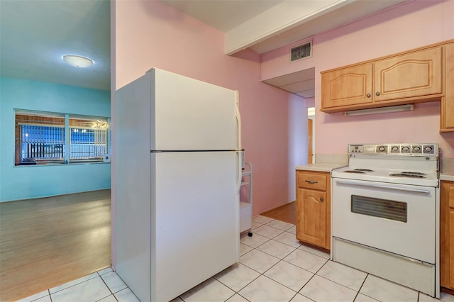 kitchen featuring white appliances, light tile patterned floors, and light brown cabinets