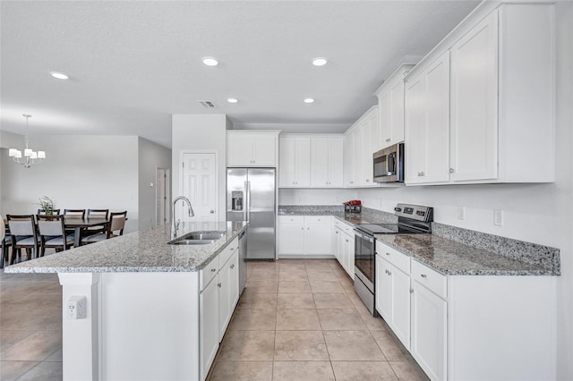 kitchen featuring sink, stainless steel appliances, an island with sink, and white cabinets