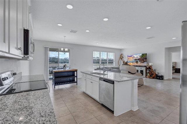 kitchen featuring appliances with stainless steel finishes, sink, white cabinets, hanging light fixtures, and a center island with sink