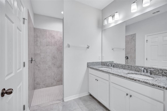 bathroom featuring tiled shower, vanity, and tile patterned floors