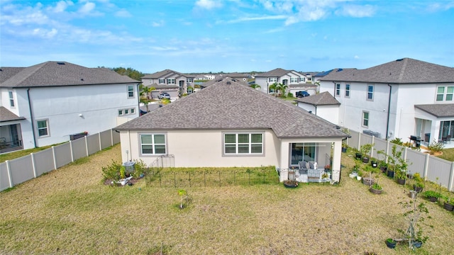 back of property with a yard and a patio area