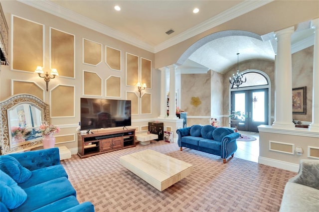 living room featuring a notable chandelier, ornamental molding, a high ceiling, and ornate columns