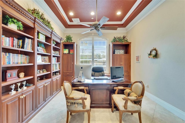 tiled home office with ornamental molding, ceiling fan, and a tray ceiling