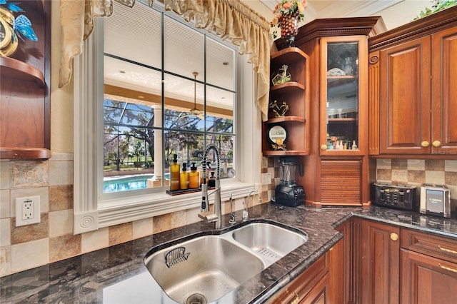 kitchen featuring dark stone counters, sink, and decorative backsplash