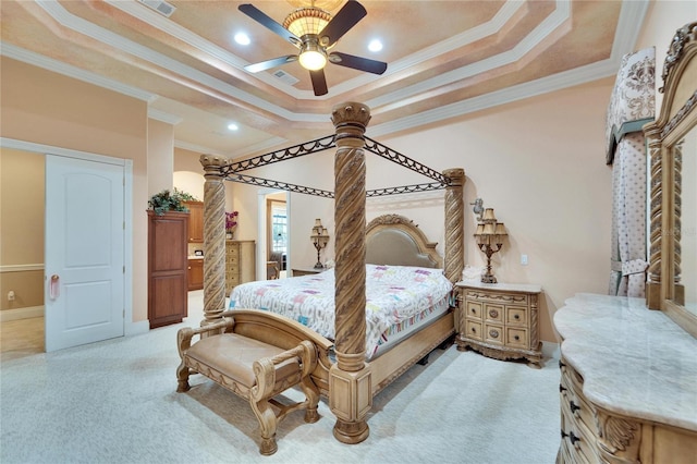 carpeted bedroom with a tray ceiling, ornamental molding, and ceiling fan