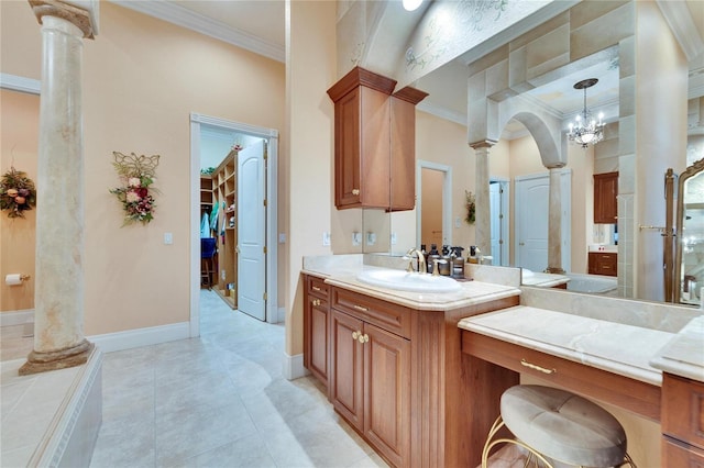 bathroom featuring a towering ceiling, decorative columns, vanity, ornamental molding, and tile patterned floors