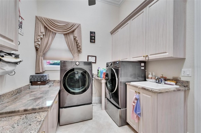 laundry room featuring sink, light tile patterned floors, cabinets, and washing machine and clothes dryer