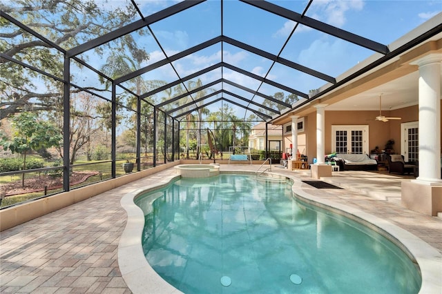 view of pool featuring glass enclosure, an in ground hot tub, ceiling fan, an outdoor hangout area, and a patio