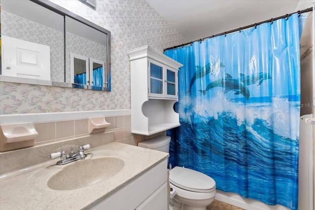 bathroom featuring vanity, tile walls, and toilet