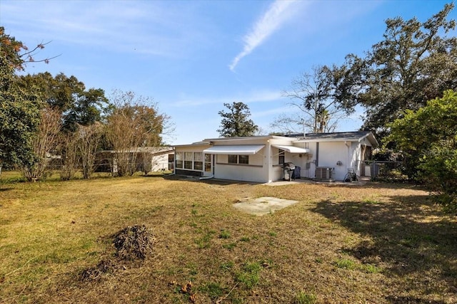 back of house with a sunroom, central AC unit, and a lawn