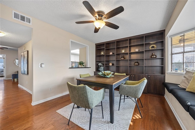 dining room featuring hardwood / wood-style flooring, ceiling fan, and a textured ceiling