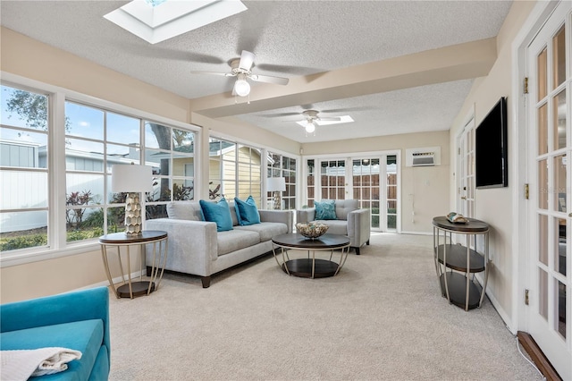 sunroom / solarium with a skylight, a wall unit AC, and ceiling fan