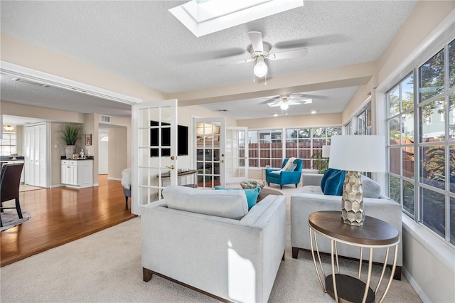 carpeted living room featuring a skylight and a textured ceiling