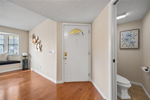 entrance foyer with a textured ceiling and light hardwood / wood-style flooring