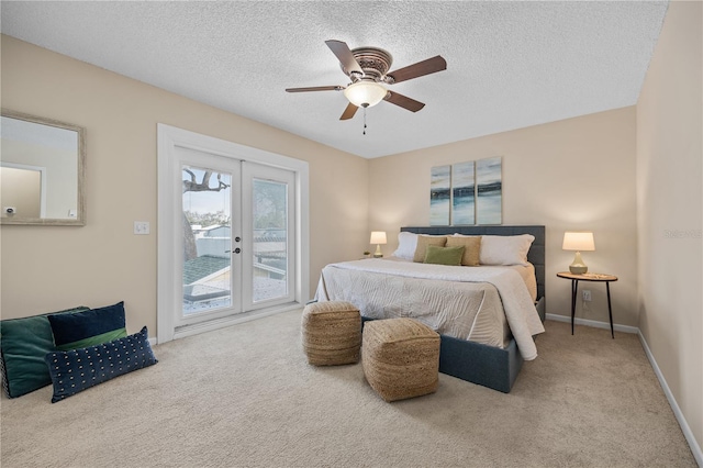 carpeted bedroom featuring ceiling fan, access to exterior, a textured ceiling, and french doors