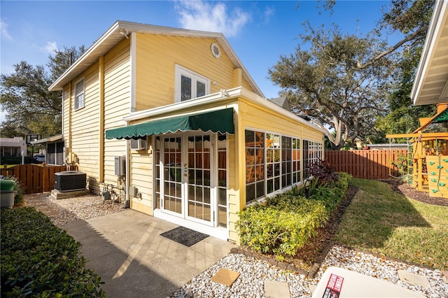 back of property with french doors, a playground, central AC, and a patio area