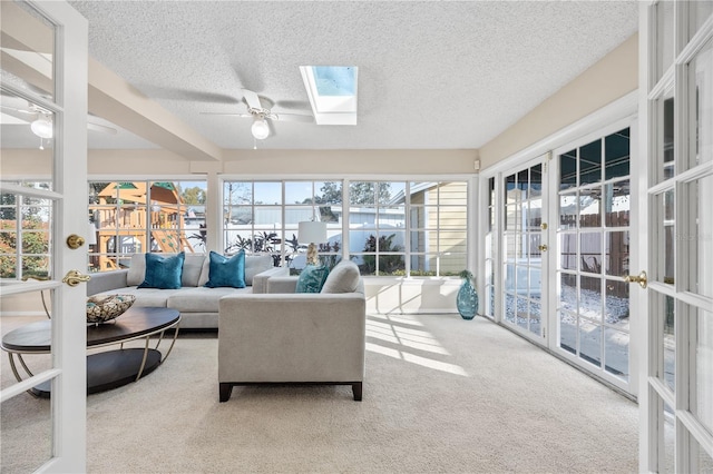 sunroom / solarium featuring a skylight, french doors, and a healthy amount of sunlight