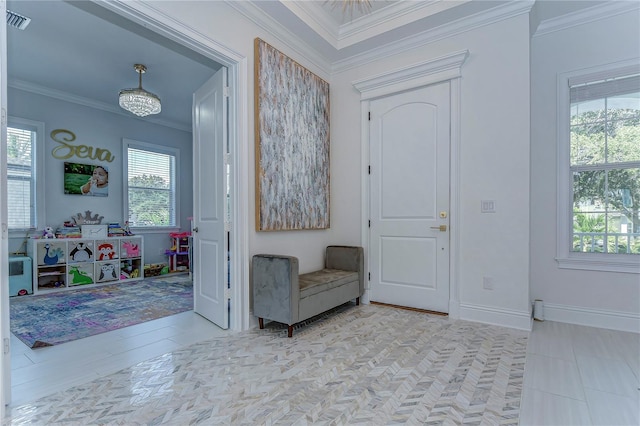 entrance foyer featuring plenty of natural light, visible vents, crown molding, and baseboards