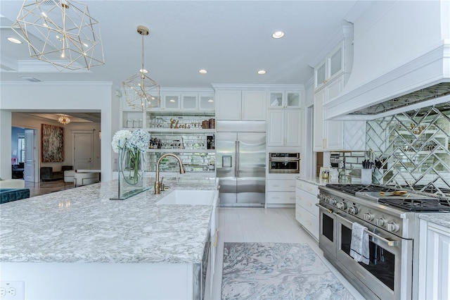 kitchen featuring custom range hood, high quality appliances, a sink, light stone countertops, and backsplash