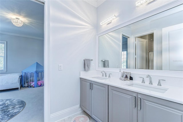 ensuite bathroom with double vanity, ornamental molding, a sink, and ensuite bathroom