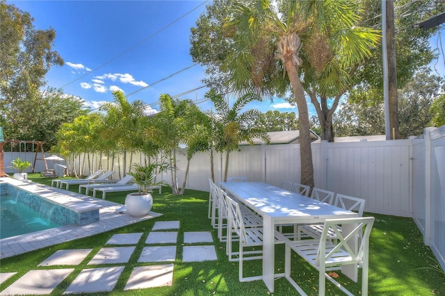 view of patio featuring outdoor dining space, a fenced backyard, and a fenced in pool