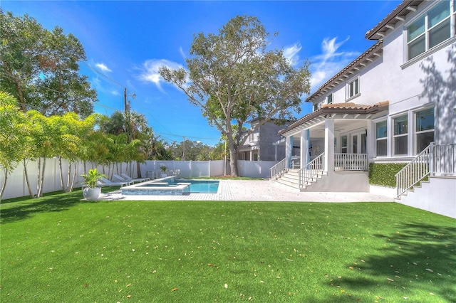 view of yard featuring a fenced backyard, a pool with connected hot tub, a ceiling fan, and a patio