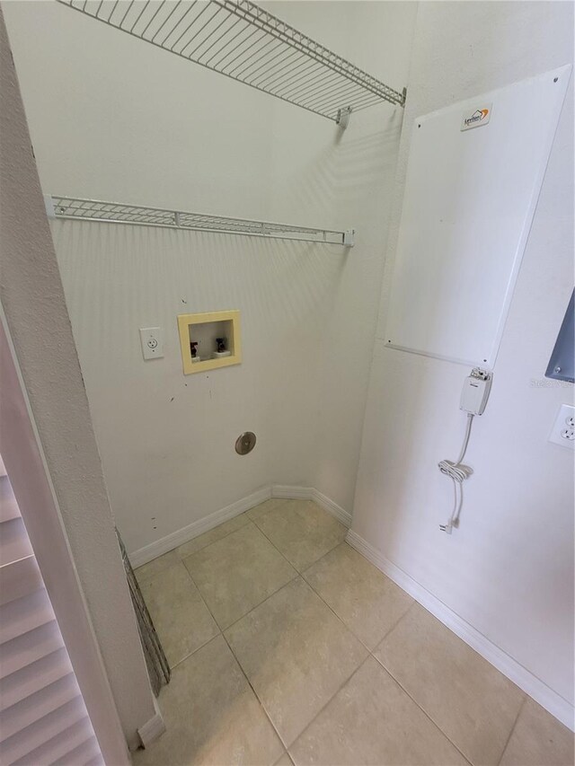 clothes washing area with light tile patterned floors, hookup for a washing machine, and electric dryer hookup