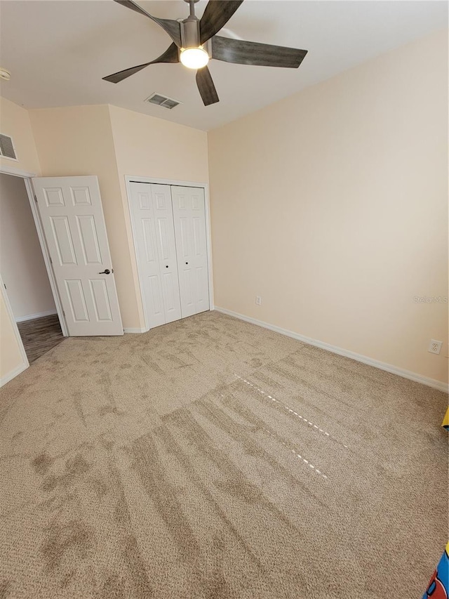 unfurnished bedroom featuring carpet floors, ceiling fan, and a closet