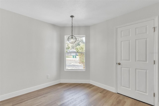 unfurnished room featuring a textured ceiling and light wood-type flooring