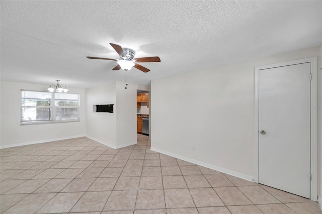 empty room featuring light tile patterned flooring, ceiling fan with notable chandelier, and a textured ceiling