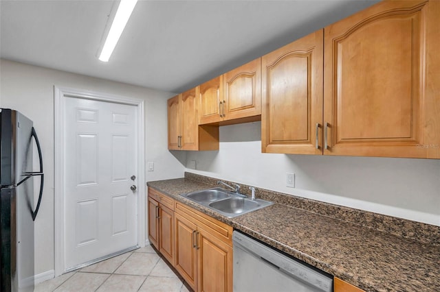 kitchen featuring light tile patterned flooring, dishwasher, sink, dark stone countertops, and fridge