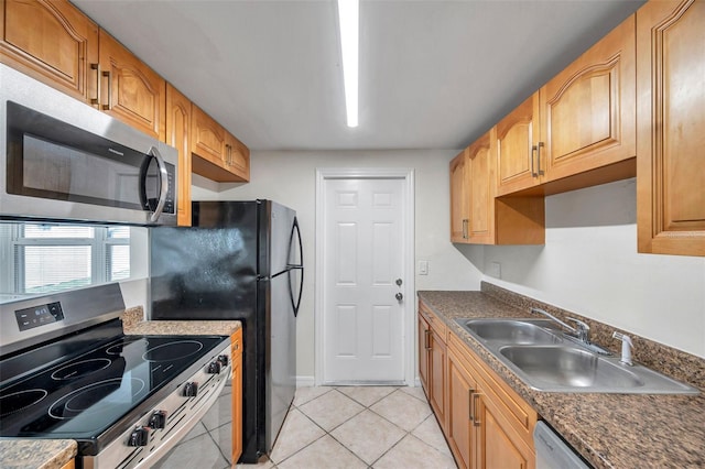 kitchen with appliances with stainless steel finishes, sink, and light tile patterned floors