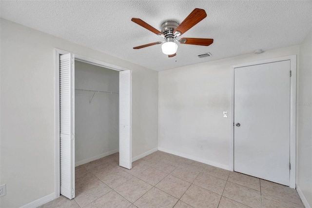 unfurnished bedroom with light tile patterned floors, a textured ceiling, and a closet