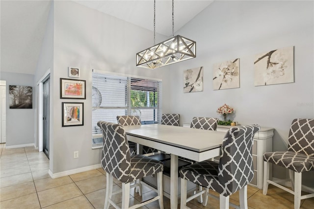 tiled dining space with high vaulted ceiling and a chandelier