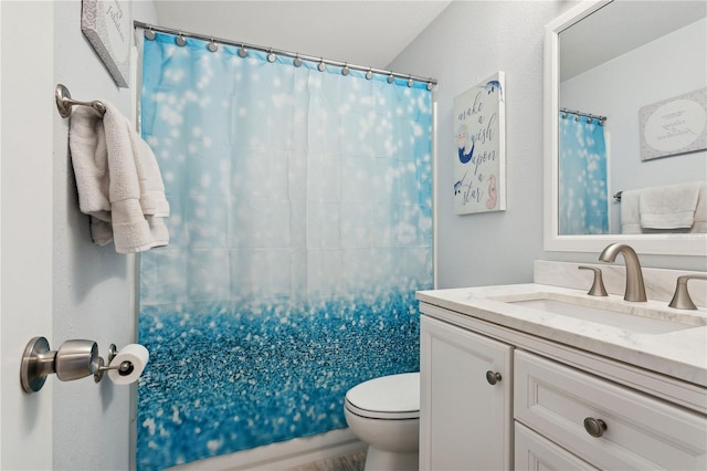 bathroom featuring vanity, toilet, and walk in shower