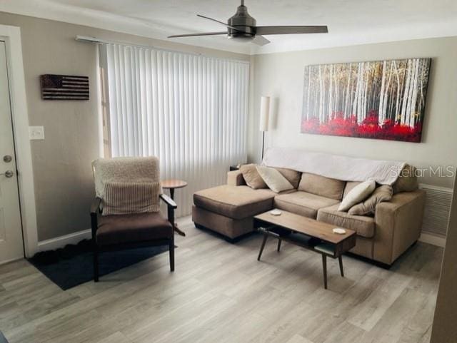 living room with ceiling fan and light hardwood / wood-style flooring