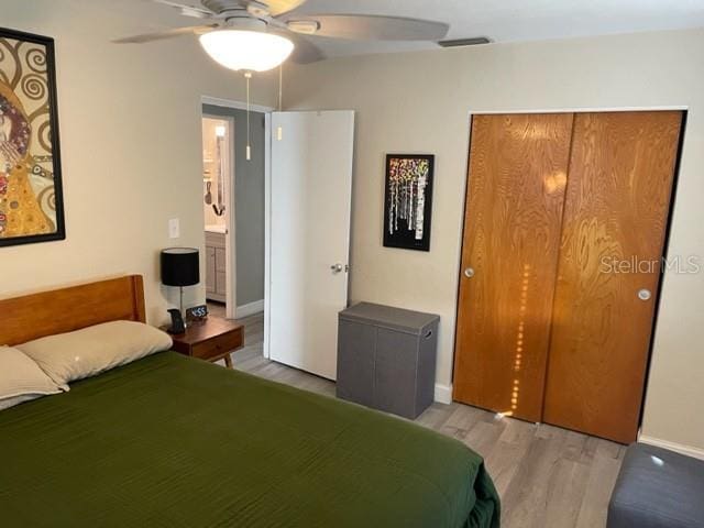 bedroom featuring hardwood / wood-style flooring, a closet, and ceiling fan